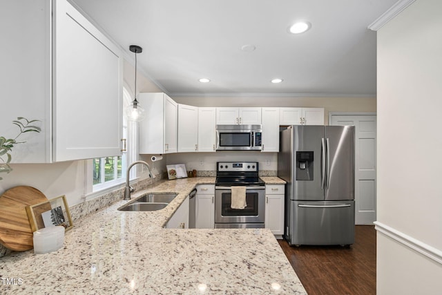 kitchen featuring white cabinets, light stone countertops, appliances with stainless steel finishes, and a sink
