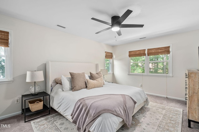 bedroom with visible vents, carpet, baseboards, and multiple windows