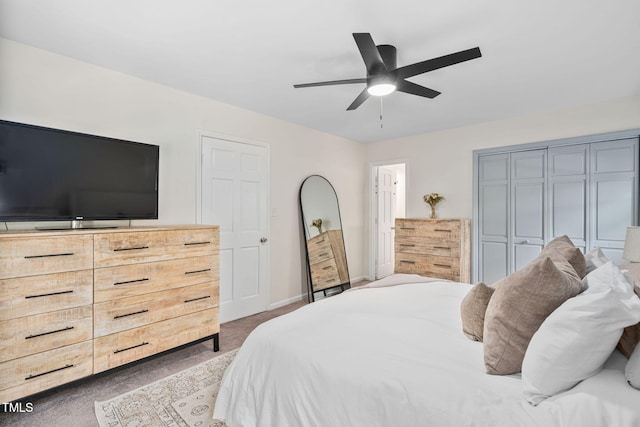 carpeted bedroom with a ceiling fan, baseboards, and a closet