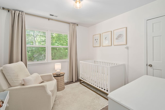 bedroom with a nursery area, baseboards, and visible vents