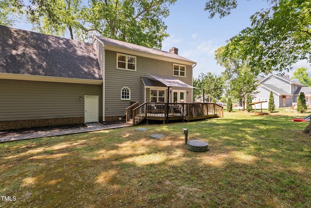 back of house with roof with shingles, a yard, a chimney, and a deck