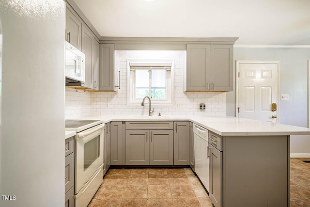 kitchen featuring white appliances, a peninsula, gray cabinetry, and decorative backsplash
