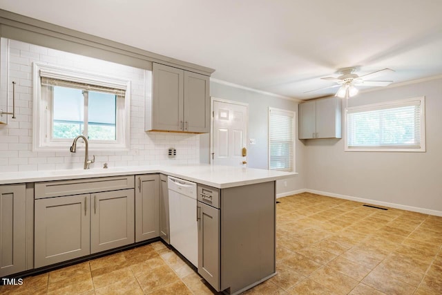 kitchen featuring a peninsula, gray cabinetry, a wealth of natural light, and dishwasher