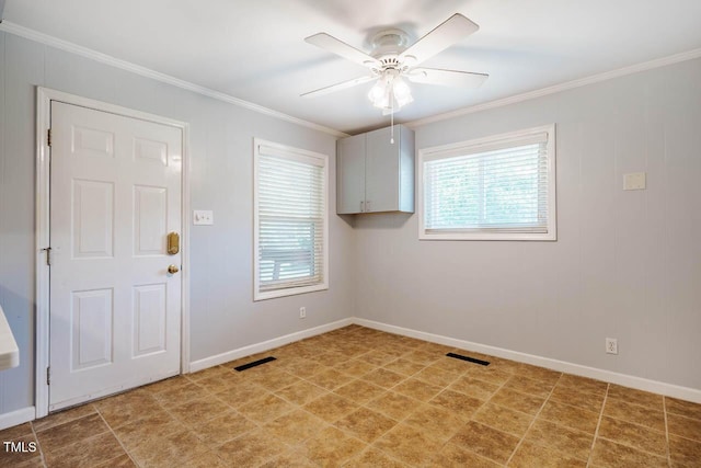 interior space featuring crown molding, baseboards, ceiling fan, and visible vents