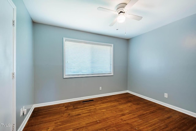 empty room with visible vents, a ceiling fan, baseboards, and wood finished floors