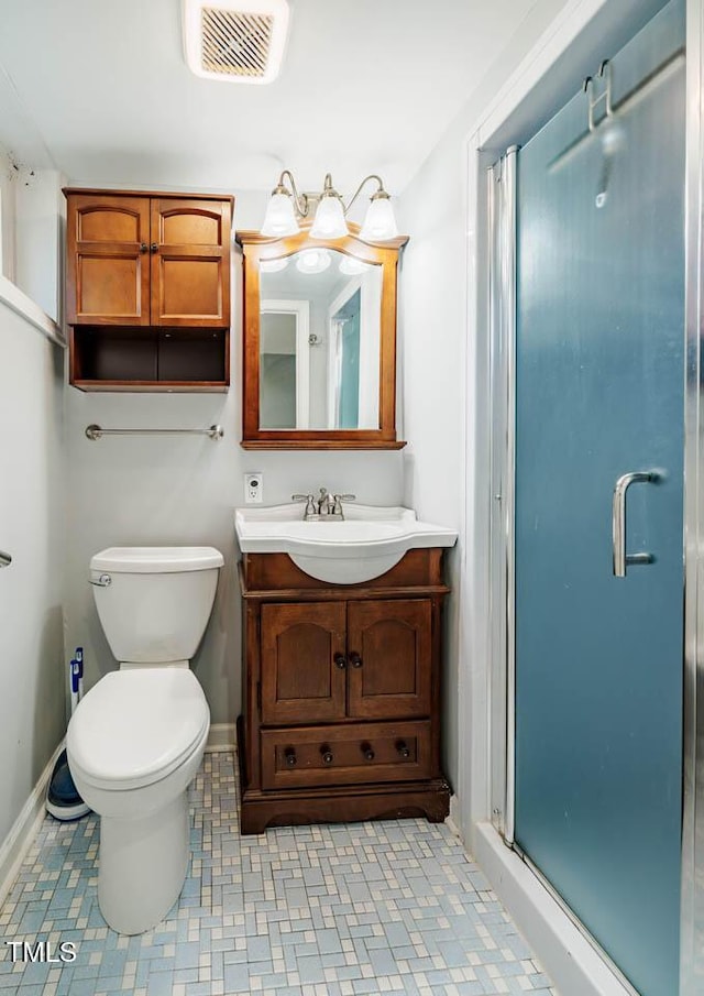 bathroom with vanity, baseboards, a stall shower, and visible vents