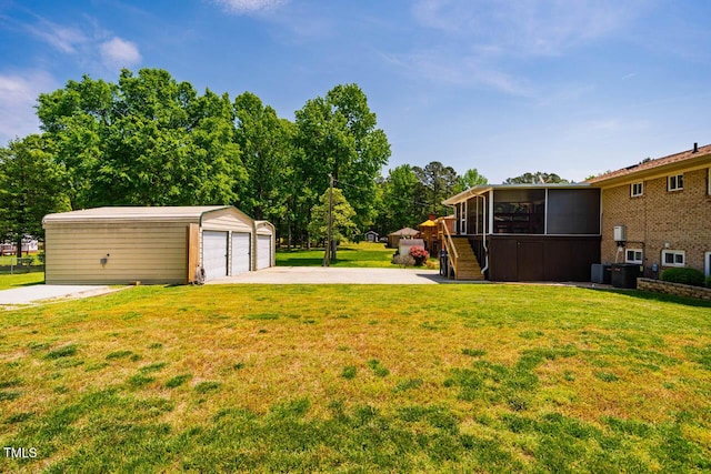 view of yard featuring a detached garage, an outdoor structure, a sunroom, and stairway