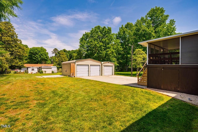 view of yard with a garage, stairs, an outdoor structure, and a sunroom