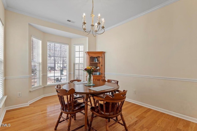 dining area with crown molding, baseboards, light wood-type flooring, and visible vents