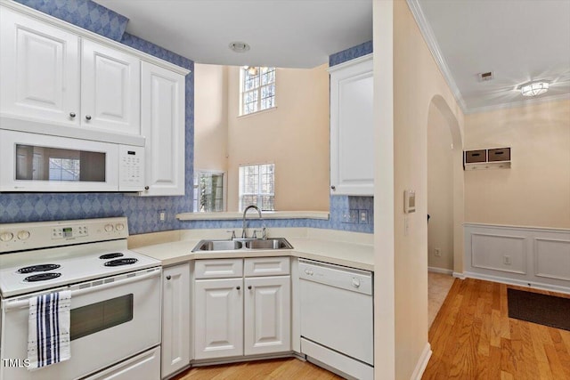 kitchen with white appliances, light countertops, a sink, and light wood-style floors