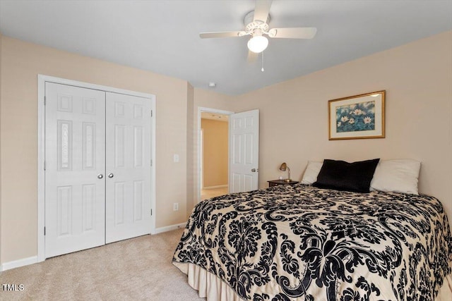 carpeted bedroom with ceiling fan, baseboards, and a closet