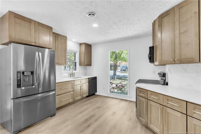 kitchen featuring a sink, stainless steel fridge with ice dispenser, light wood-style floors, light countertops, and dishwasher