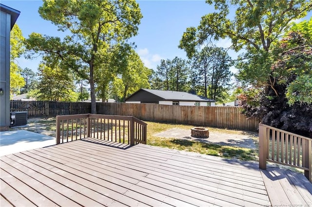 wooden deck featuring a patio, a fire pit, a fenced backyard, and central AC unit