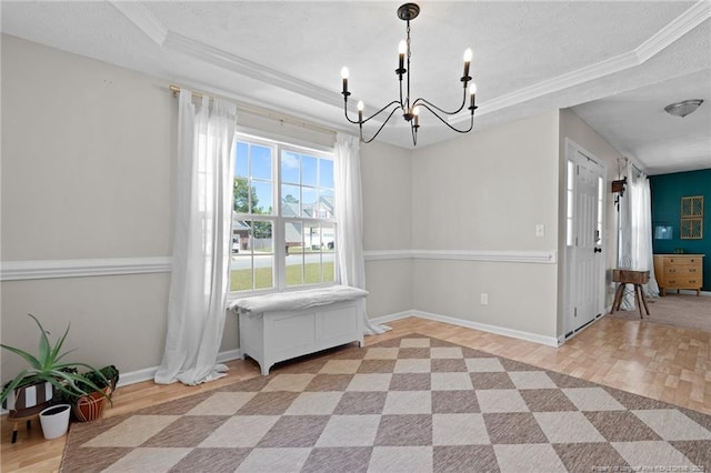 dining area with a tray ceiling, a notable chandelier, and ornamental molding