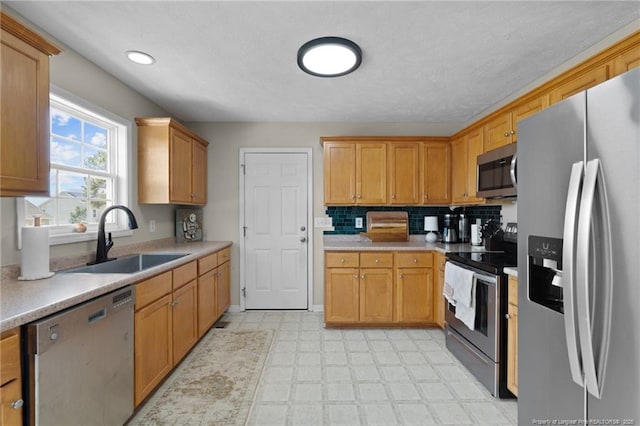 kitchen featuring a sink, appliances with stainless steel finishes, light countertops, and light floors