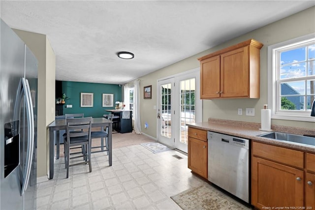 kitchen featuring a sink, appliances with stainless steel finishes, plenty of natural light, and french doors