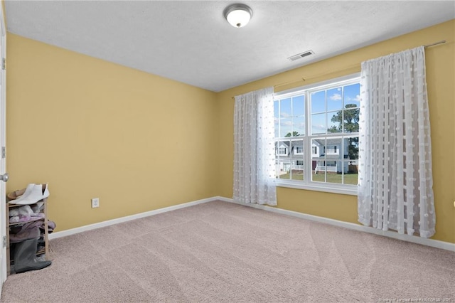 empty room featuring baseboards, carpet, and visible vents