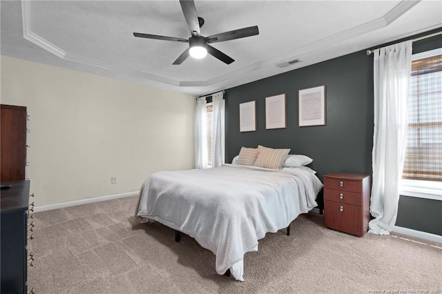 bedroom featuring a raised ceiling, baseboards, and carpet flooring
