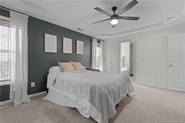 bedroom featuring baseboards, light colored carpet, multiple windows, and a raised ceiling