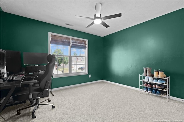 office space featuring ceiling fan, a textured ceiling, carpet, baseboards, and visible vents