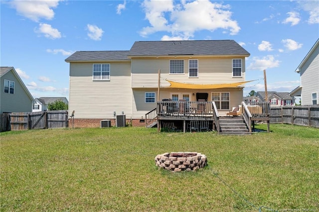 back of property featuring a fire pit, a wooden deck, cooling unit, a fenced backyard, and a yard