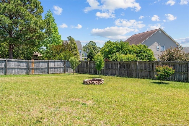 view of yard featuring a fenced backyard and a fire pit