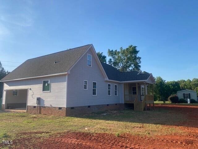 rear view of house with a garage, a yard, crawl space, and covered porch