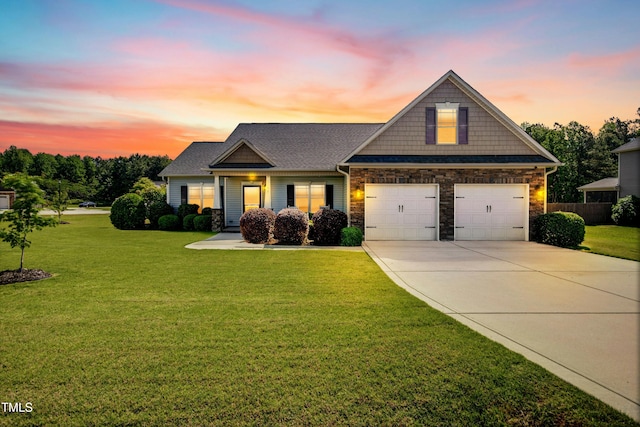 craftsman house with a lawn, a garage, fence, concrete driveway, and stone siding