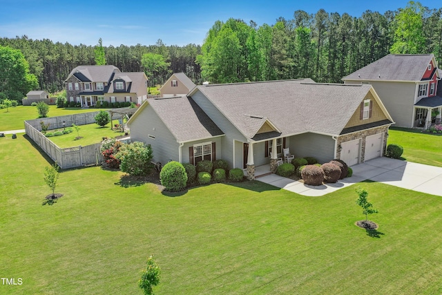 view of front facade with fence, driveway, a front lawn, and a garage