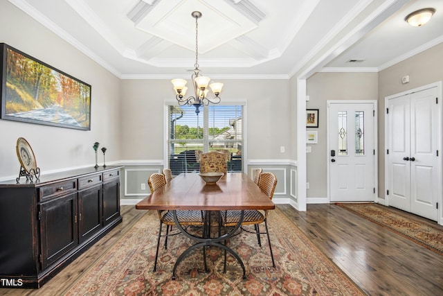 dining room featuring a notable chandelier, a wainscoted wall, wood finished floors, visible vents, and ornamental molding