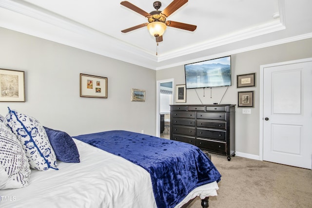 bedroom with carpet flooring, a tray ceiling, and ornamental molding