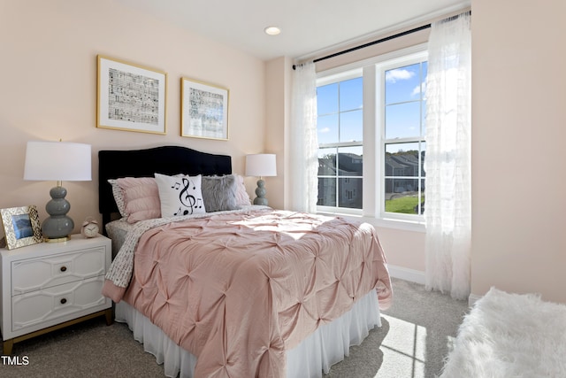 bedroom with baseboards, multiple windows, and carpet flooring