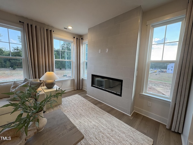 5906 Dunzo Dr, Raleigh, NC 27617 - living area with wood finished floors, a tiled fireplace, and recessed lighting