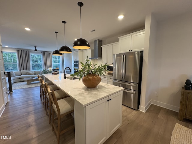 5906 Dunzo Dr, Raleigh, NC 27617 - kitchen with appliances with stainless steel finishes, wall chimney range hood, open floor plan, dark wood finished floors, and white cabinets
