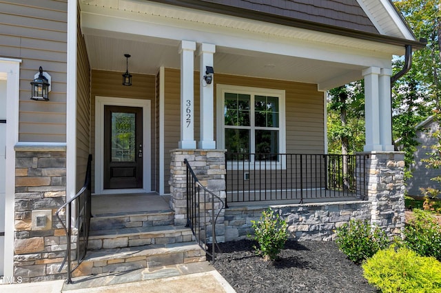 property entrance featuring a porch and stone siding
