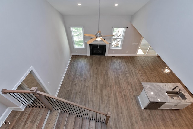 unfurnished living room featuring stairway, baseboards, and wood finished floors