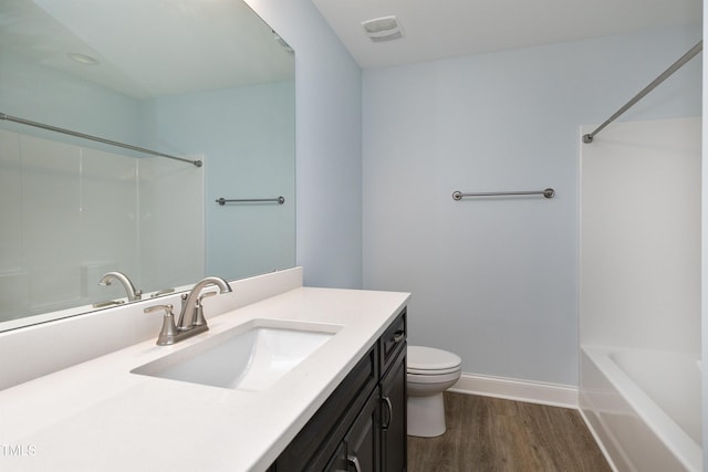 bathroom featuring visible vents, wood finished floors, baseboards, vanity, and toilet