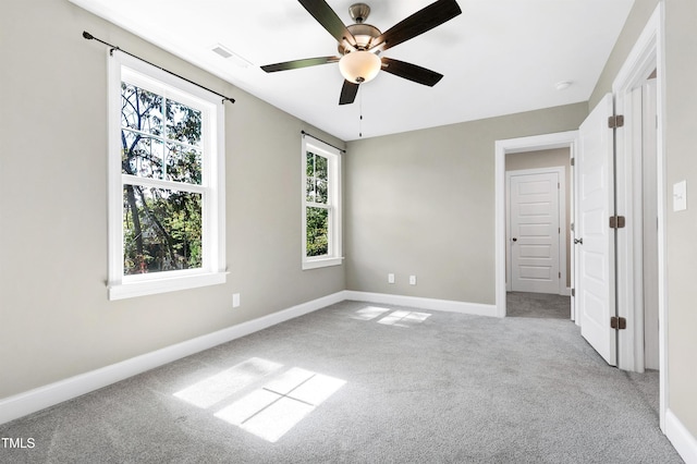 unfurnished bedroom featuring a ceiling fan, baseboards, visible vents, and carpet