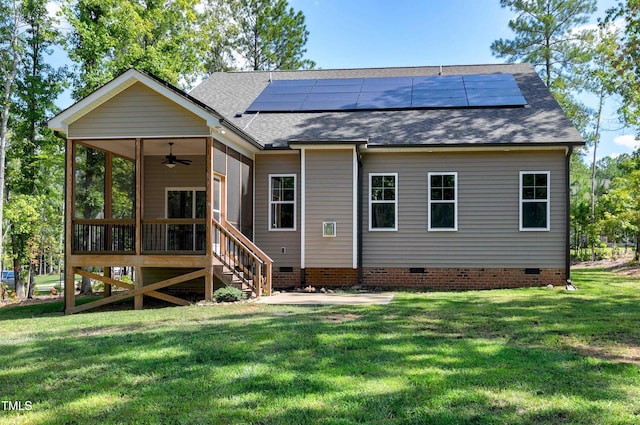 rear view of house featuring a sunroom, a ceiling fan, a shingled roof, crawl space, and solar panels