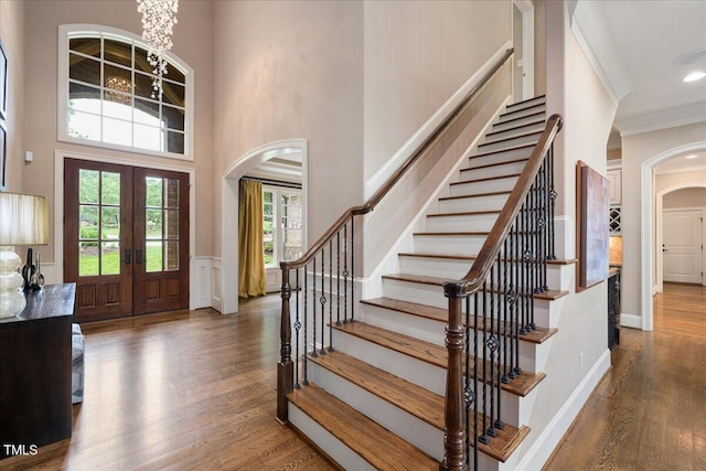3601 Nightfall Ct, Raleigh, NC 27607 - foyer with arched walkways, french doors, stairs, ornamental molding, and wood finished floors