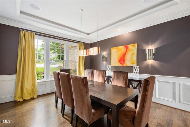 3601 Nightfall Ct, Raleigh, NC 27607 - dining room with a tray ceiling, a decorative wall, ornamental molding, wainscoting, and wood finished floors
