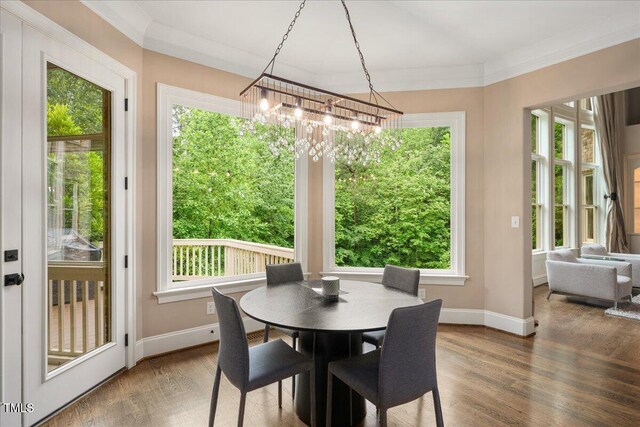 3601 Nightfall Ct, Raleigh, NC 27607 - dining room with a chandelier, wood finished floors, baseboards, and crown molding