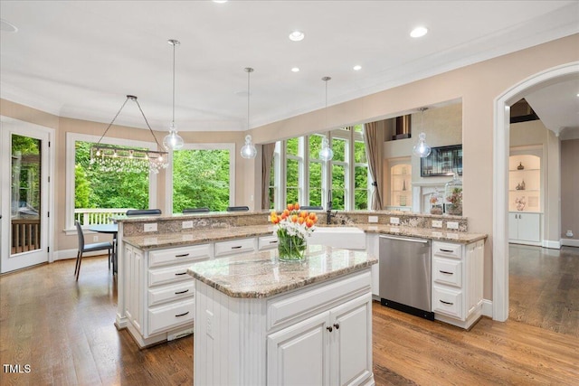 3601 Nightfall Ct, Raleigh, NC 27607 - kitchen with dishwasher, a kitchen island, arched walkways, wood finished floors, and white cabinets
