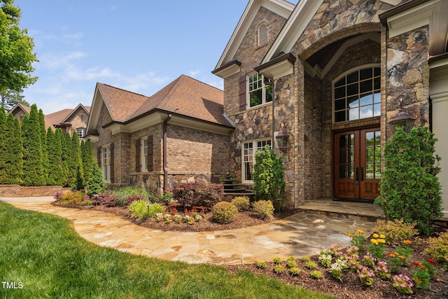 3601 Nightfall Ct, Raleigh, NC 27607 - doorway to property featuring french doors, stone siding, brick siding, and roof with shingles