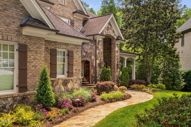 3601 Nightfall Ct, Raleigh, NC 27607 - entrance to property featuring stone siding, a shingled roof, and brick siding