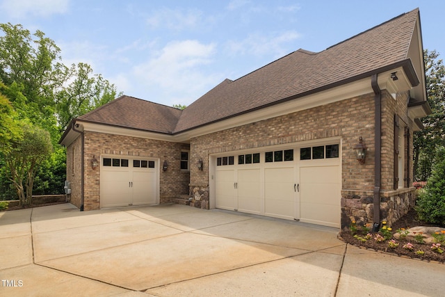 3601 Nightfall Ct, Raleigh, NC 27607 - view of side of property featuring an attached garage, concrete driveway, roof with shingles, and brick siding