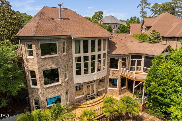 3601 Nightfall Ct, Raleigh, NC 27607 - rear view of property featuring a sunroom, brick siding, a shingled roof, and french doors