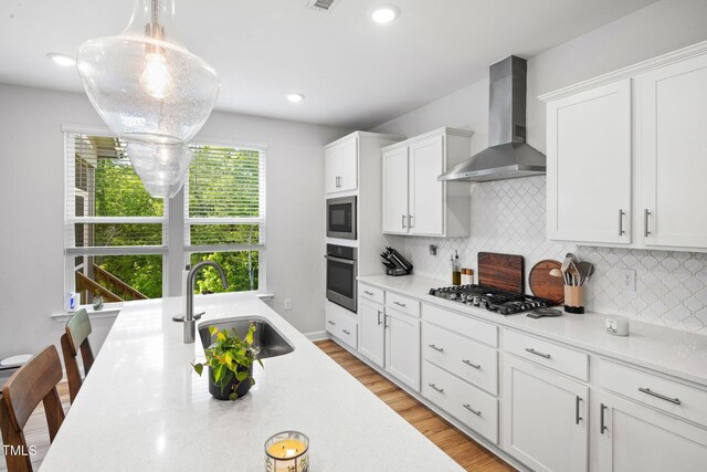 521 Marion Hills Way, Knightdale, NC 27545 - kitchen with appliances with stainless steel finishes, a sink, light countertops, wall chimney exhaust hood, and backsplash