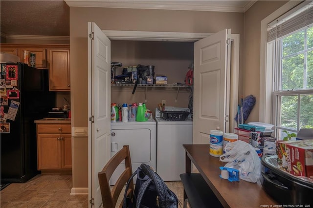 laundry area featuring crown molding, light tile patterned floors, laundry area, and washing machine and clothes dryer