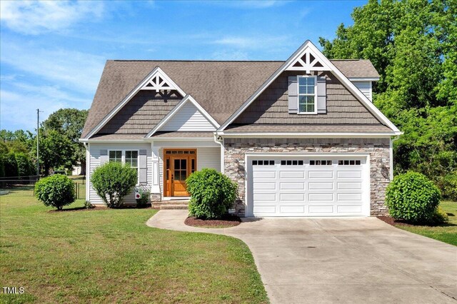 2062 Montgomery Dr, Franklinton, NC 27525 - craftsman-style house with driveway, a front lawn, a garage, stone siding, and a shingled roof